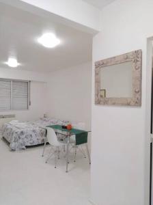 Habitación blanca con cama, mesa y sillas en Studio Aguero - Recoleta en Buenos Aires