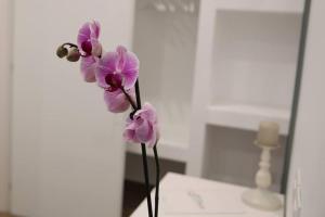 Une bande de fleurs violettes dans un vase sur une table dans l'établissement Essence, à Barletta