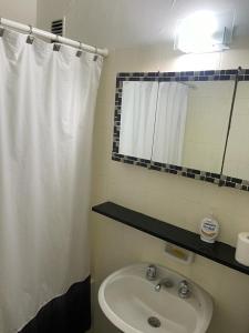 a bathroom with a sink and a shower curtain at Obelisco in Buenos Aires