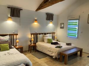 a bedroom with two beds and a window at "La Petite Félixière" in Saint-André-de-la-Marche