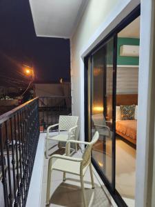 a balcony with two chairs and a bed at Hotel La Casona MC in La Romana