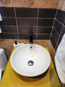 lavabo blanco en una encimera amarilla en el baño en Hotel La Casona MC en La Romana
