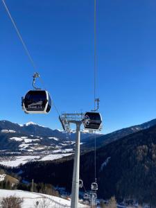 a ski lift with two chairs on a ski slope at Sci Trekking Bike al Plan de Corones Kronplatz Dolomiti in Sorafurcia