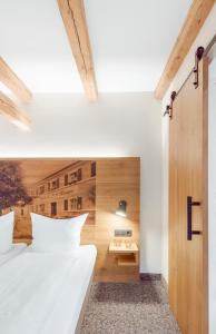 a bedroom with two white beds and a wooden wall at Zum Alten Fritz in Weigendorf