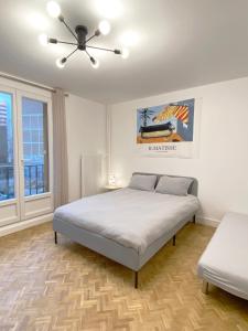 sypialnia z łóżkiem i wentylatorem sufitowym w obiekcie Paris: agréable chambre d’un grand artiste w Paryżu