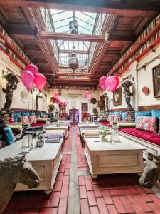 un restaurante con mesas y globos rosas en una habitación en Divná pani Luxury Gallery Rooms, en Banská Štiavnica