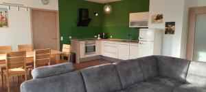 a living room with a couch and a table and a kitchen at Ferienwohnung Kopold "Im alten Schulhaus" in Pöttmes