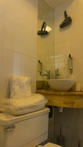 uma casa de banho com um lavatório, um WC e um espelho. em Dei Templi Apart Hotel em Viña del Mar