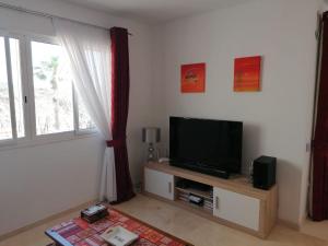 un soggiorno con TV a schermo piatto e finestra di Exquisite modern 2-Bed House in El Pinar de Bedar a Bédar