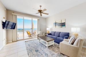 a living room with a blue couch and a tv at Spanish Key 408 in Pensacola