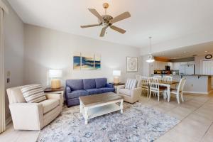 a living room with a blue couch and a table at Spanish Key 408 in Pensacola