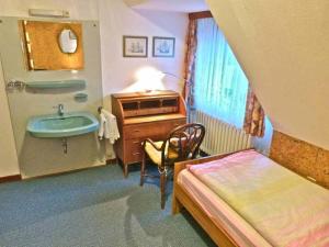 內貝爾的住宿－Friedrichs-5-EZ，一间带水槽的浴室和一张位于客房内的床