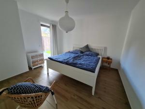 a bedroom with a bed with blue sheets and a window at Ruegen Ferienhaus 300 in Sehlen