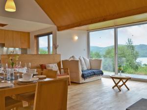 a kitchen and living room with a table and a couch at West Bothy in Glenborrodale