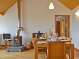 a dining room with a table and a wood stove at West Bothy in Glenborrodale