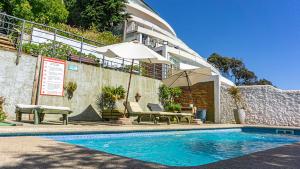 a swimming pool with chairs and umbrellas next to a building at Dei Templi Hotel in Viña del Mar +40 photos