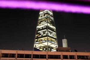 利雅德的住宿－Business Inn Olaya，一座高大的建筑,晚上有紫色的灯光