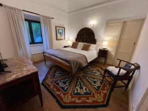 um quarto com uma cama, uma mesa e uma cadeira em Quinta do Caçador em Estremoz