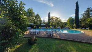 una piscina con tavoli e sedie in un cortile di Country Hotel Poggiomanente a Umbertide