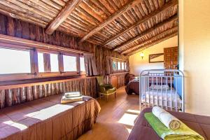 Sant Pere de VilamajorにあるCatalunya Casas Nature and Tranquility for 24 pax - 30km to beachのベッド2台とベビーベッド1台が備わる客室です。