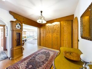 een woonkamer met een grootvaders klok en een tapijt bij Schnitzerstube in Mittenwald