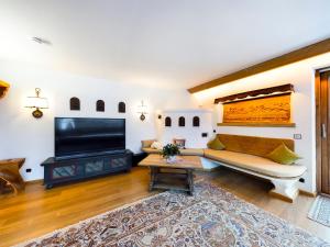 uma sala de estar com um sofá e uma televisão de ecrã plano em Schnitzerstube em Mittenwald
