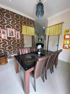 une salle à manger avec une table et des chaises en cuir dans l'établissement Homestay Affan03 Gong Badak Dekat UNISZA & 500 meter dari Pantai, à Kampong Tanjong Gelam