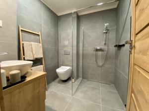 uma casa de banho com um chuveiro, um WC e um lavatório. em Apartmány Kellov Dom em Demanovska Dolina
