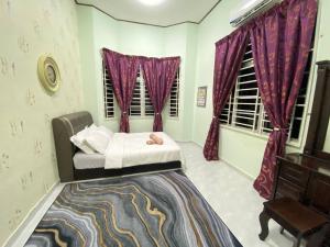 - une chambre avec un lit et des rideaux violets dans l'établissement Homestay Affan03 Gong Badak Dekat UNISZA & 500 meter dari Pantai, à Kampong Tanjong Gelam