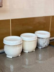 trois bols blancs posés sur le sol à côté d'un mur dans l'établissement Homestay Affan03 Gong Badak Dekat UNISZA & 500 meter dari Pantai, à Kampong Tanjong Gelam 21 autres photos