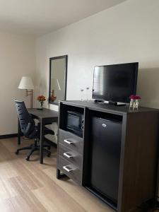 a hotel room with a television and a desk with a chair at The Scout INN in Cody