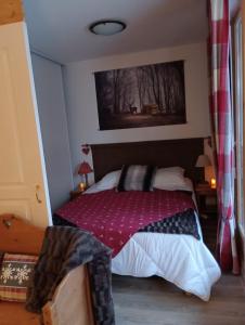 - une chambre avec un lit et une couverture rouge dans l'établissement Appart. lumineux à St-Sorlin d'Arves (Sybelles), à Saint-Sorlin-dʼArves