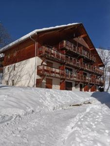 un grand bâtiment avec de la neige devant lui dans l'établissement Appart. lumineux à St-Sorlin d'Arves (Sybelles), à Saint-Sorlin-dʼArves