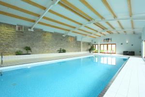 an indoor swimming pool with a brick wall at Dumble Cottage in Ashbourne