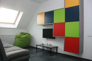 een woonkamer met een kleurrijke muur en een tv bij Ferienwohnung Die Himmlische in Kleve