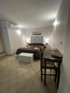 a bedroom with a bed and a table and a desk at Normanni Central House in Palermo