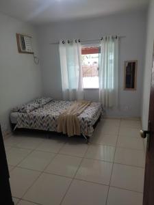 een slaapkamer met een bed en een raam bij Recanto de Araruama in Araruama