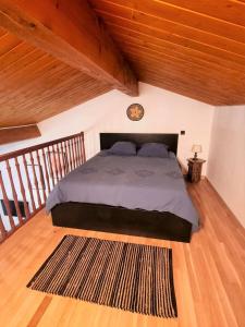 1 dormitorio con 1 cama con techo de madera en Le Chalet, en Charbonnières-les-Bains