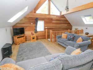 uma sala de estar com dois sofás e uma televisão em The Boathouse em Tenby