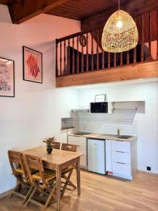 cocina con mesa de madera y cocina con fregadero en Le Chalet, en Charbonnières-les-Bains