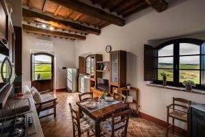 een keuken en eetkamer met een tafel en stoelen bij Podere Fossaccio Casa Olivo in Asciano