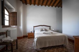 a bedroom with a large bed and a window at Podere Fossaccio Casa Olivo in Asciano