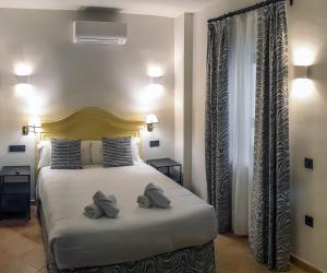 sypialnia z łóżkiem i dwiema poduszkami w obiekcie Turistic Apartment Sevillanos SL w Sewilli