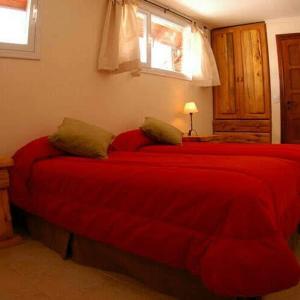 a red bed in a bedroom with a red blanket at Las Asturianas in San Carlos de Bariloche