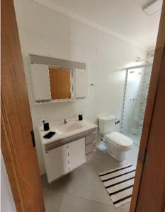 ein weißes Bad mit einem Waschbecken und einem WC in der Unterkunft Apto térreo novo 2 Dorm - próximo ao Centro in Poços de Caldas