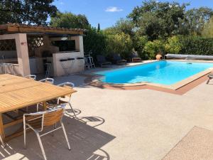 einen Pool mit einem Tisch, einem Tisch und Stühlen in der Unterkunft Villa climatisée, piscine privée chauffée, Fitness proche Cannes, Fréjus, St Raphael, Grasse in Montauroux