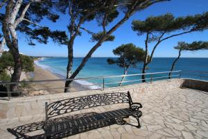 ミアミ・プラトーヤにあるApartamento Mar i Celの浜辺の石道に腰掛けたベンチ
