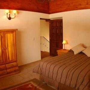 a bedroom with a bed and a dresser in a room at Las Asturianas in San Carlos de Bariloche