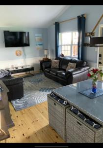 ein Wohnzimmer mit einem Sofa und einem Tisch in der Unterkunft Seaside chalet,Aboiteau beach cottage rentals,cap pele in Cap-Pele