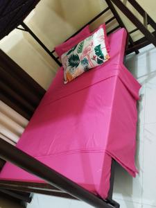 Litera rosa con almohada en 30pax-Jumongs Transient Inn, en Bantay
